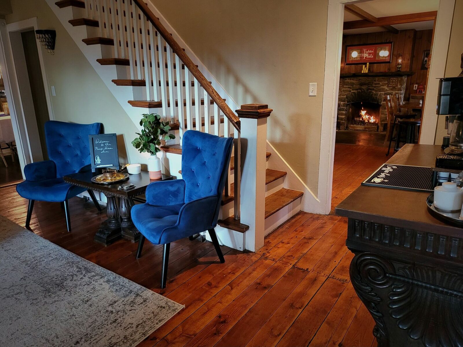 Two blue velvet chairs by the staircase in the Pump House foyer.