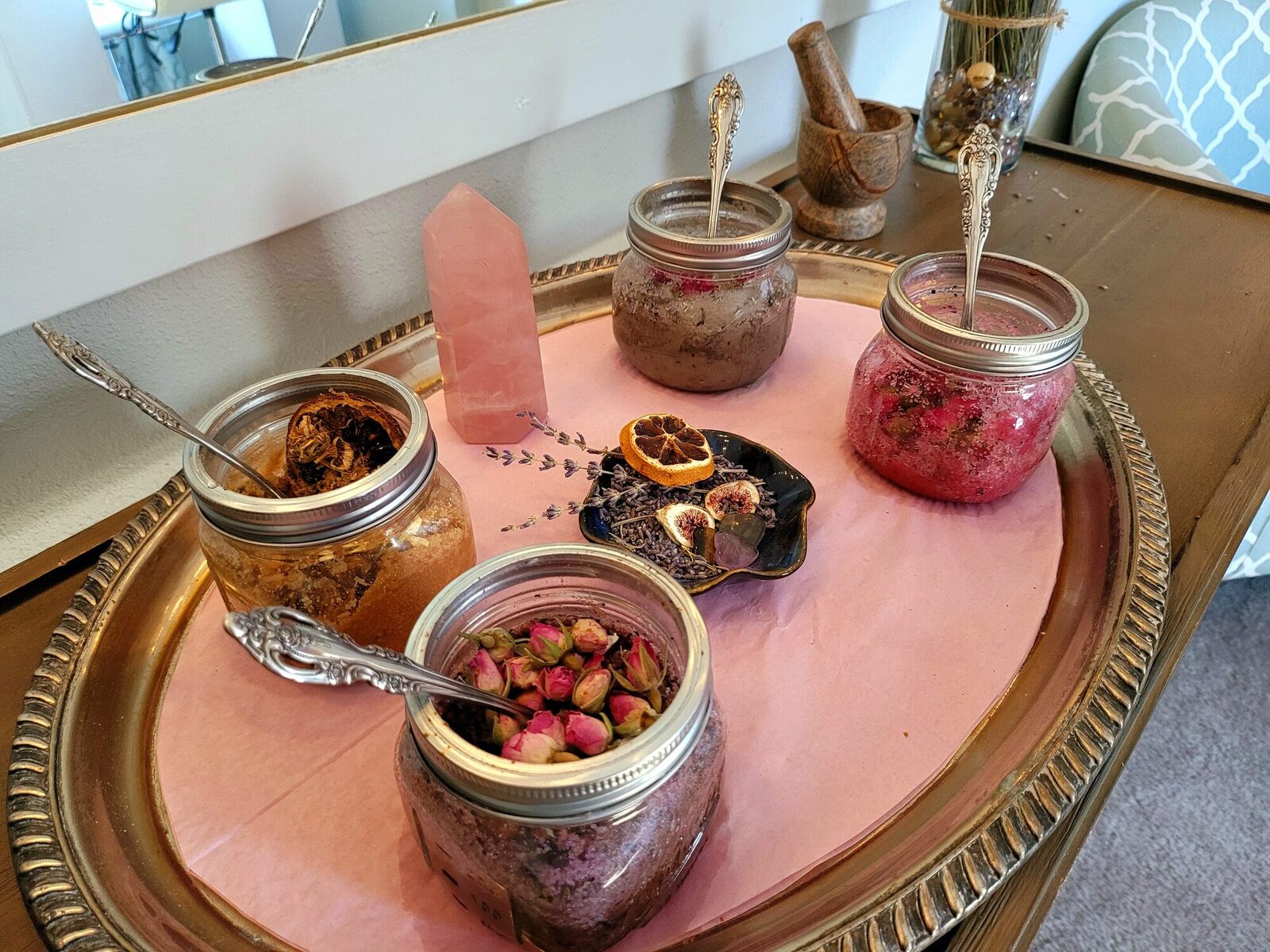 Four soak blends in glass jars on an antique tray with rose buds and lavender.